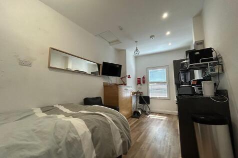A cozy single bedroom featuring a neatly made b...