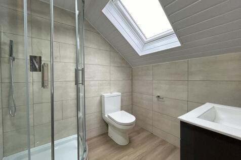 A modern bathroom featuring a corner shower wit...