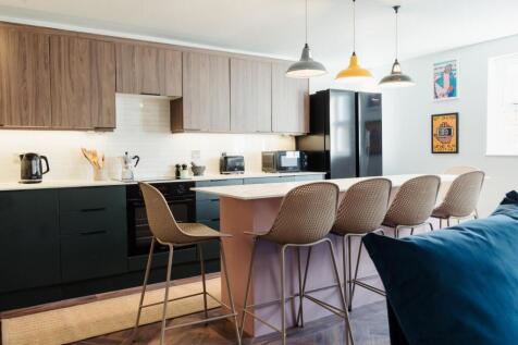 Modern kitchen featuring a large island with se...