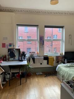Bright master bedroom featuring large windows t...
