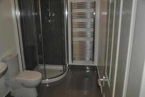 Modern bathroom featuring a curved glass shower...
