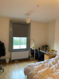 A cozy single bedroom with wooden flooring, a l...