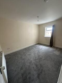 A spacious double bedroom featuring soft carpet...