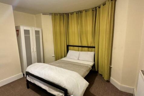 Cozy double bedroom featuring a well-made bed w...