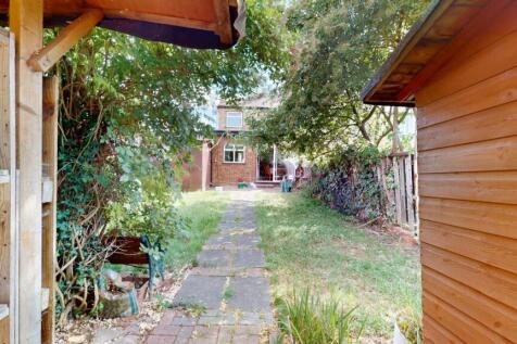 A charming garden space featuring a paved pathw...