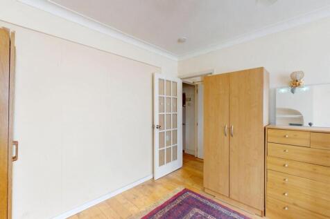 A clean and bright room featuring wooden wardro...
