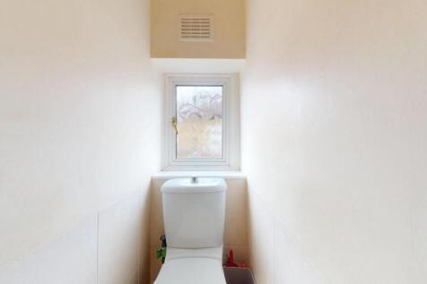 A clean and bright small toilet room featuring ...