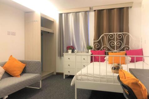 A cozy double bedroom featuring a stylish white...
