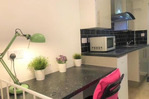 A compact and tidy kitchen area featuring a sle...