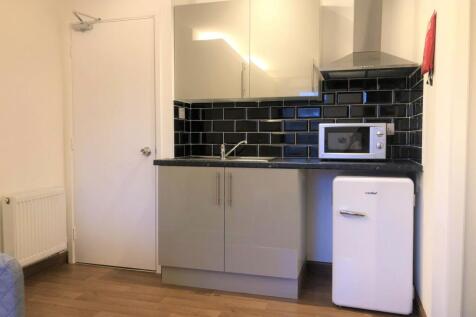 A modern compact kitchen featuring sleek grey c...
