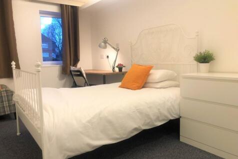 Bright and cozy single bedroom featuring a cris...