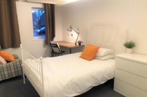 A cozy single bedroom featuring a crisp white m...