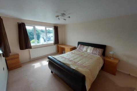 A spacious and well-lit bedroom featuring a com...