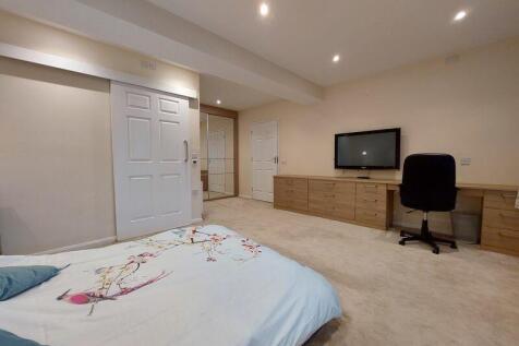 A spacious and neatly arranged bedroom featurin...