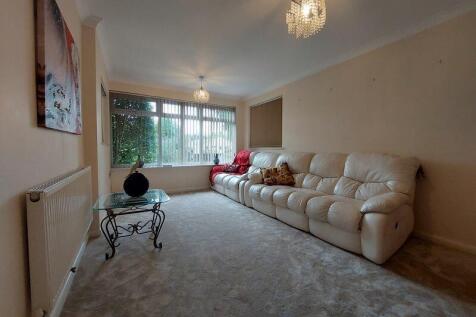 A cozy living room featuring a large cream leat...