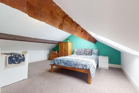 Spacious double bedroom featuring a cozy bed an...