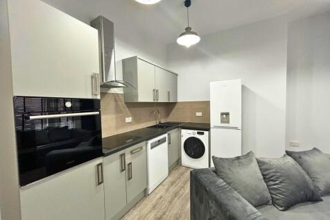 Modern kitchen area with sleek cabinetry, integ...