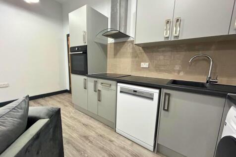 Modern kitchen area featuring sleek grey cabine...