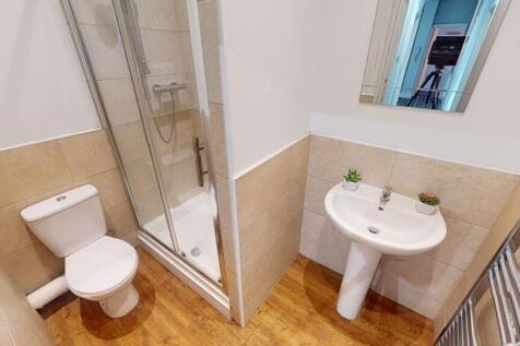 A neat and tidy bathroom featuring a shower enc...