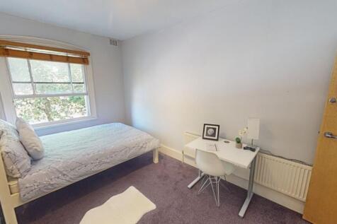 A bright and cozy single bedroom with a comfort...