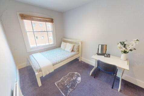 A bright, tidy single bedroom featuring a comfo...