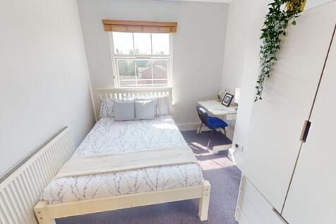 Bright and cozy single bedroom featuring a neat...