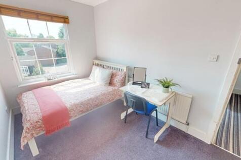 A bright and tidy single bedroom featuring a be...