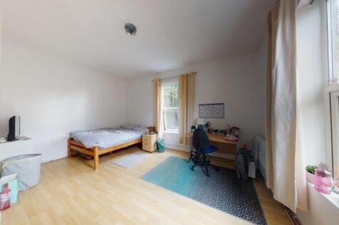 A bright and tidy single bedroom featuring a co...