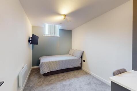 A spacious and tidy double bedroom featuring a ...