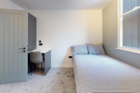 A bright and inviting double bedroom with a com...