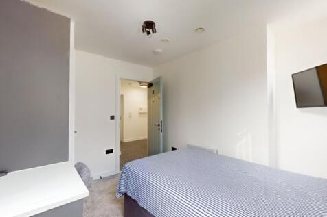 A spacious and tidy double bedroom with modern ...