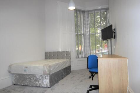 A bright single bedroom with a modern bed and a...