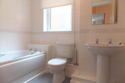 Bright and clean bathroom suite featuring a spa...