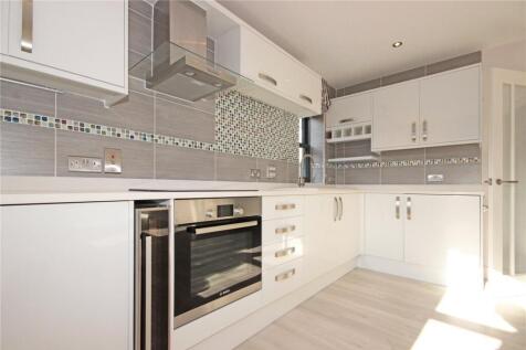 Bright and modern kitchen featuring ample white...