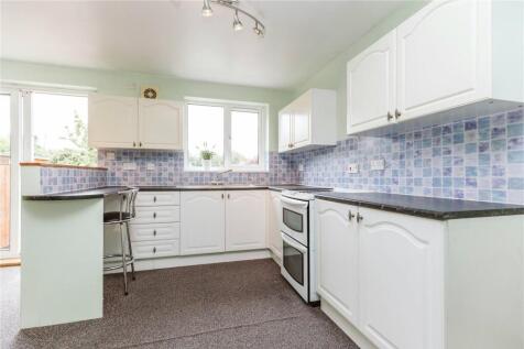 Bright and tidy kitchen featuring ample white c...