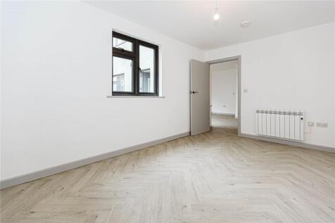 A clean, modern small room with a window provid...