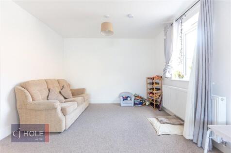 A bright and tidy living room with a large wind...