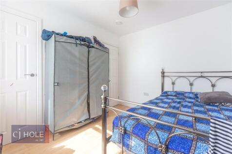 A bright double bedroom featuring a metal bed f...