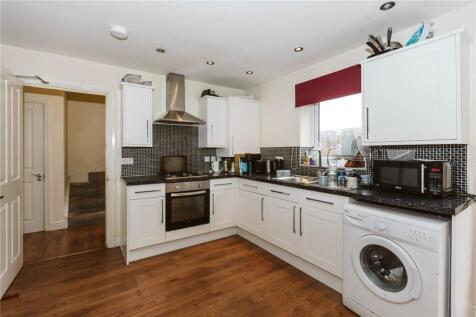 Bright and modern kitchen featuring white cabin...