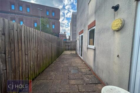 A narrow paved pathway alongside a residential ...