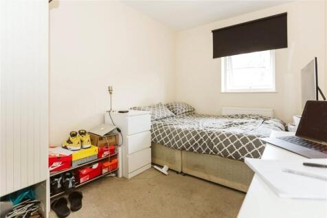 A neat and cozy single bedroom featuring a comf...