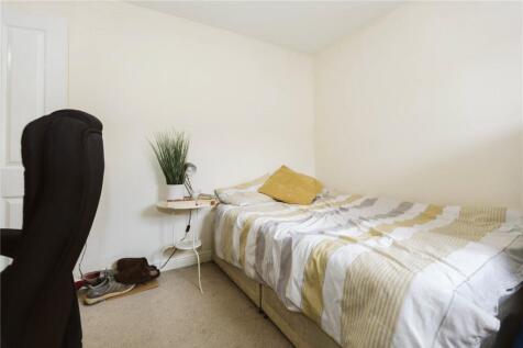 A cozy single bedroom featuring a neatly made b...