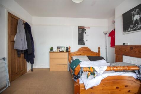 A cozy single bedroom featuring a wooden bed an...