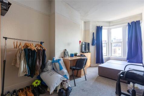 A cozy and well-lit single bedroom featuring a ...