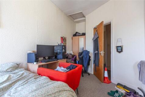 Cozy single bedroom featuring a comfortable bed...