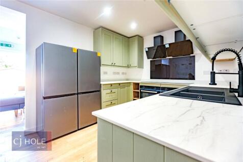 A modern kitchen featuring sleek cabinetry, a l...