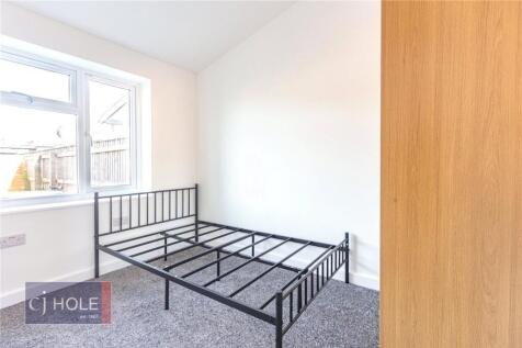 Bright and tidy bedroom featuring a large windo...