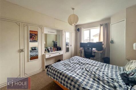 A spacious and well-lit master bedroom featurin...