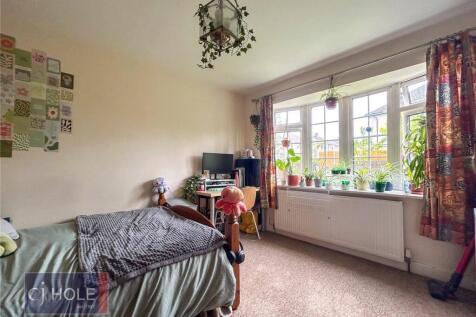 A cozy single bedroom featuring a comfortable b...