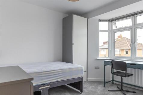 A bright and tidy room featuring a large window...